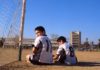 Dos niños uniformados esperan el inicio de un partido junto a la portería de un campo de fútbol de albero. Rodrigo Ferrari