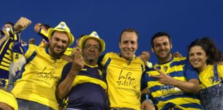 Algunos miembros de la Peña Exilio Cadista posan durante un partido con camisetas del conjunto amarillo. FPC
