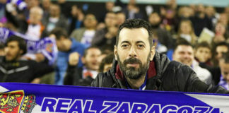 Un aficionado del Real Zaragoza extiende su bufanda durante un encuentro disputado en La Romareda. FPRZ